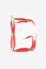 Obraz na płótnie Canvas Bold letter G Latin alphabet of red hot chili pepper on a white background