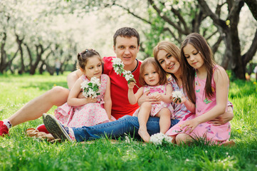 Fototapeta na wymiar big family with three little daughters spending time together in summer park, mother, father and sisters having fun outdoor