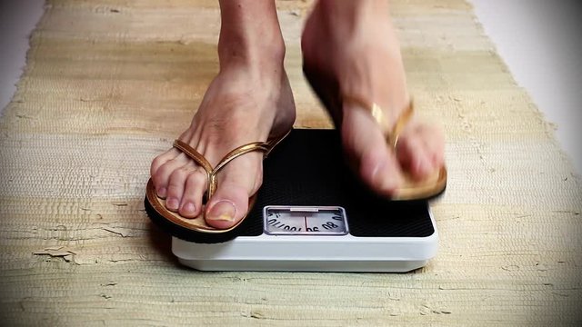 Overweight woman on a scale. Lifestyle and healthcare footage. 