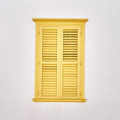 yellow window shutters on pale white wall