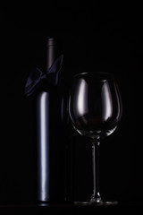 black red wine bottle with empty tall glass
