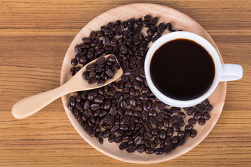 Coffee cup and beans on wooden background