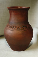 One clay pot on the background of linen cloth close up