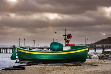 Naklejka na ściany i meble Fishing Boat on the beach of Baltic sea at storm