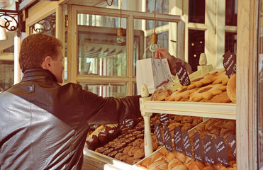 A man buys products in bakery shop