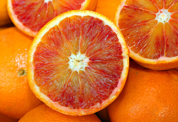 oranges and an orange cut in the stall of greengrocer