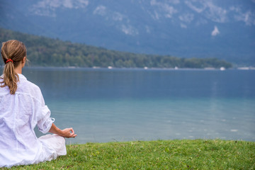 Fototapeta premium Woman meditating at the lake