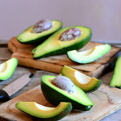 Ripe cut pieces avocado on a wooden board. Delicious and healthy food