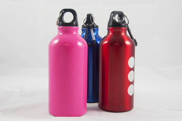 three multi colored metallic bottles 