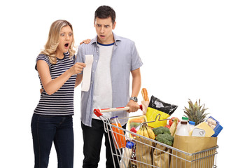 Shocked young couple looking at a shopping bill