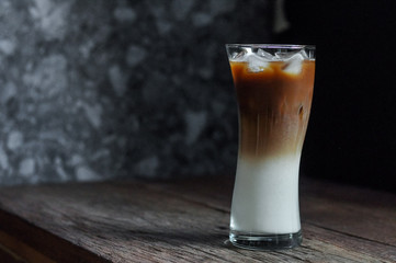 Refreshing iced coffee latte on wooden table in restaurant and cafe