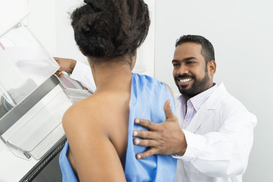 Smiling Doctor Assisting Patient Undergoing Mammogram X-ray Test