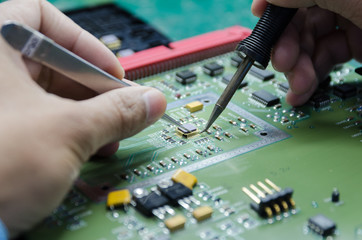 Engineer repair circuit board with soldering iron