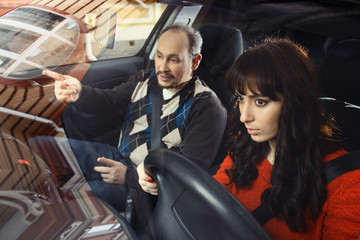 Father teaching daughter how to drive a car