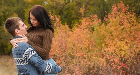 girl at the hands of Man. A loving couple walking in the autumn park.