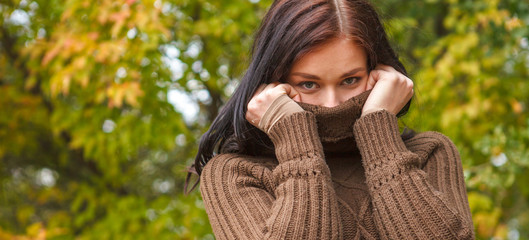 beautiful girl in a brown pullover in autumn park