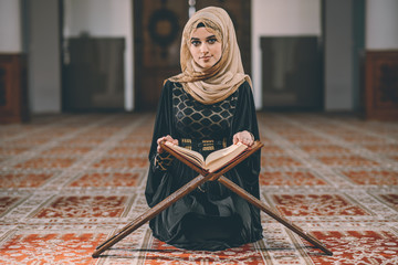 Muslim woman reading and reciting Muslim holy book Koran