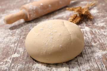 raw dough with rolling pin