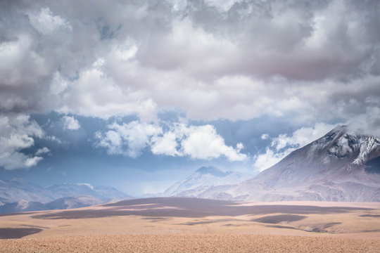 Storm over volcano peaks in the dry desert of the high Andes. Volcanoes in the Andes Mountain range, Chile border with Bolivia, South America.