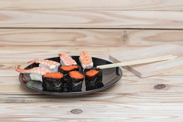 Sushi Close up in black plate on wooden background, Asian food delicious