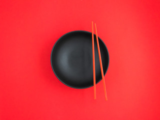 Black and shallow soup bowls with chopsticks.