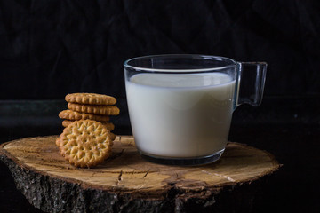 fresh healthy milk and stack of cookies on black background