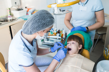 dentist and nurse curing childe teeth