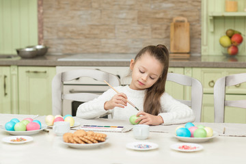 Obraz na płótnie Canvas little girl having fun to paint easter eggs