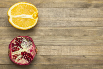 pomegranate and orange fruit lay on wooden table