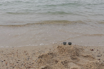 Sunglasses Select focus with shallow depth of field on beach sand