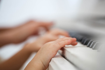 Child's fingers put on piano keys
