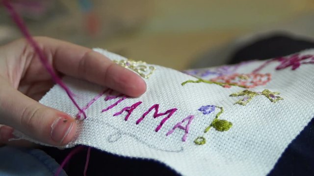 Creative teen girl embroiders a gift for her mother