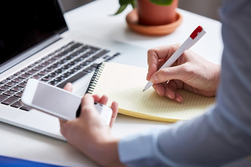 office work. woman writes a note at the workplace