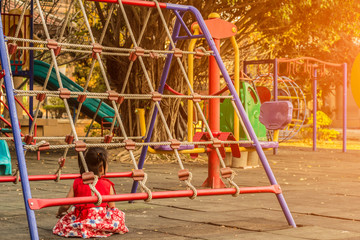 Little girl sitting at playground park.