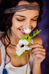 Charming lady smiles smelling white flower