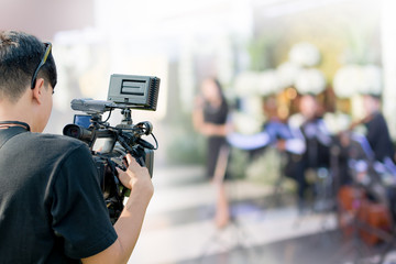 Covering an event on stage with a video camera.