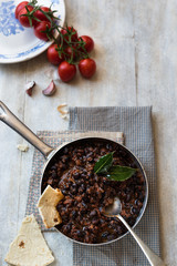 chili vegetariano speziato con fagioli neri su base rustica di legno, tortilla e pomodori. Vista dall'alto