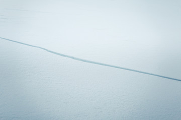 A beautiful cracked ice along the frozen river in Norwegian winter