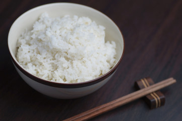 Thai rice with chopsticks on wood background