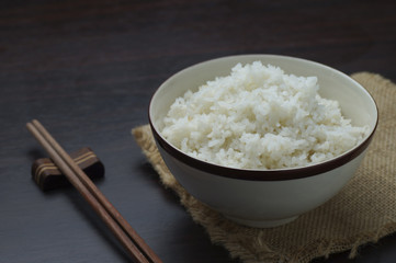 Thai rice with chopsticks on wood background