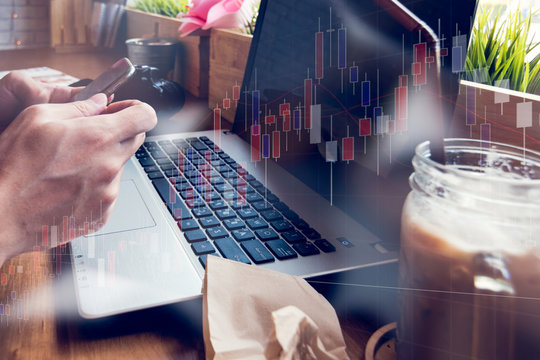 Businessman Is Working With His Computer In Coffee Shop With Stock Chart And Data Overlay.