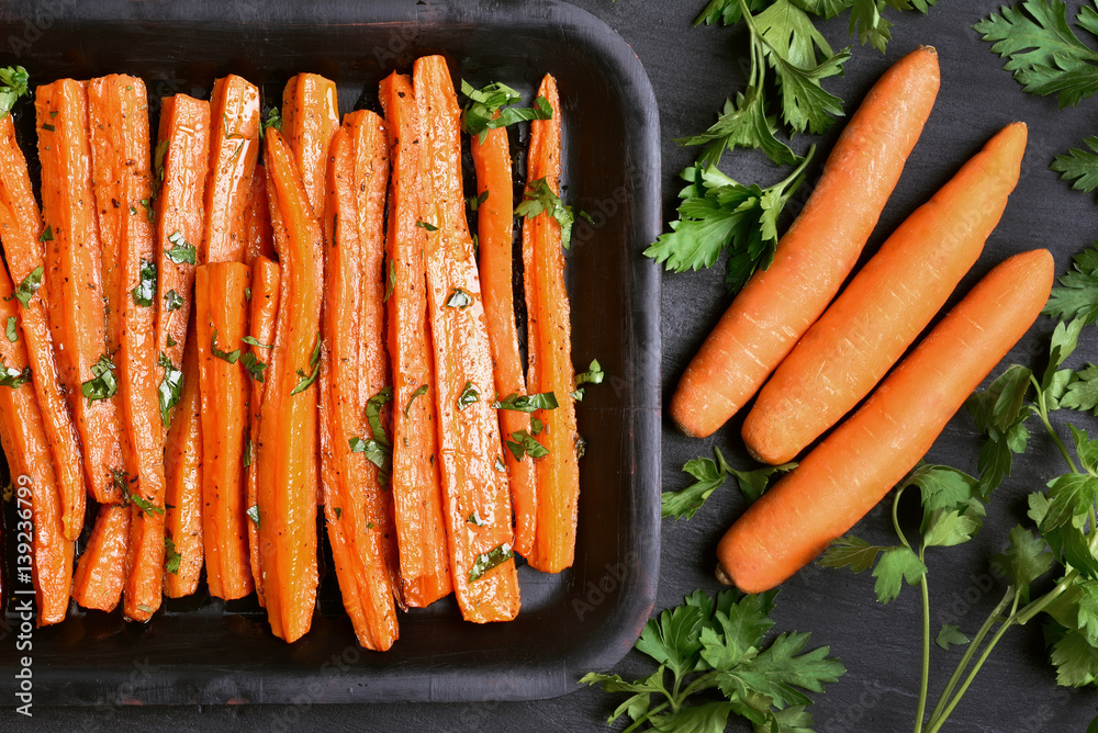 Wall mural baked carrots with green herbs