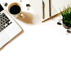 Modern minimalistic work place. White office desk table with laptop, coffee cup, clips, notebook, pen and penclil. Top view with copy space, flat lay