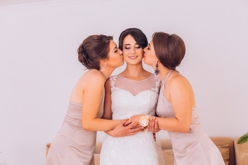 Bride and bridesmaids on the wedding day embracing each other and smiling