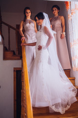 Bride and bridesmaids on the wedding day embracing each other and smiling