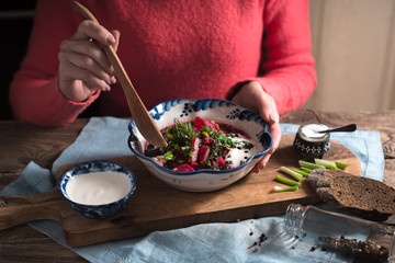 Woman eating traditional beetroot soup borscht horizontal