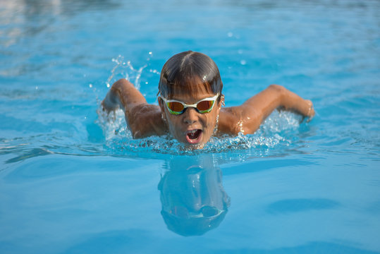 Close up action swimming boy butterfly style with gogles
