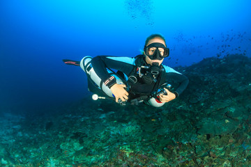 Female SCUBA diver using a techical side mount system on a deep coral reef - obrazy, fototapety, plakaty