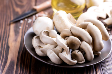 Fresh mushrooms on a wooden background  Bottle with olive oil