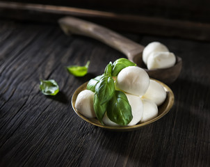 mini mozzarella and basil on a wooden background